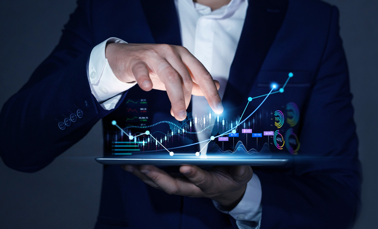 Businessman holding tablet with growing virtual hologram of statistics, graph and chart.Business strategy development and growing growth plan. Investment of growth on currency rate.